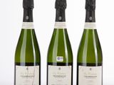 trois bouteilles de champagne posées côte à côte sur une table