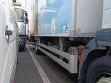 two trucks that are parked next to each other on the street