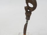statue of a bird on top of a wooden stick on a clear base