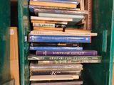 une boîte verte remplie de livres posée sur une table en bois