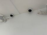 two surveillance cameras on the wall of a room