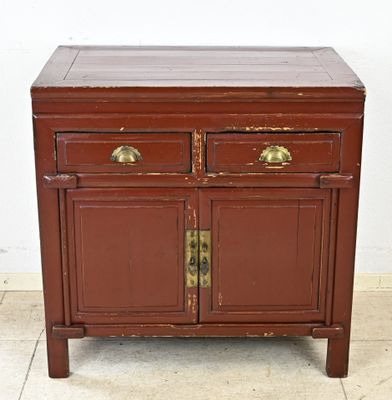 une petite armoire en bois avec deux tiroirs et une porte