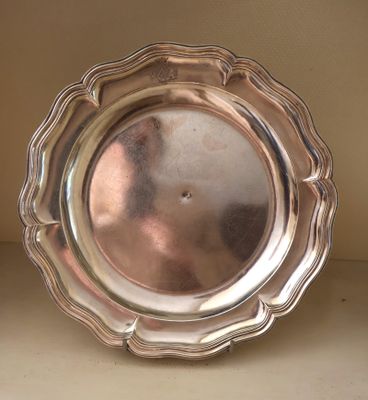 a silver plate sitting on a shelf on a shelf
