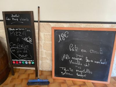 un tableau noir sur lequel sont écrites des notes, à côté d'un effaceur en bois