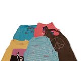Quatre t-shirts sont alignés en rang sur une surface blanche