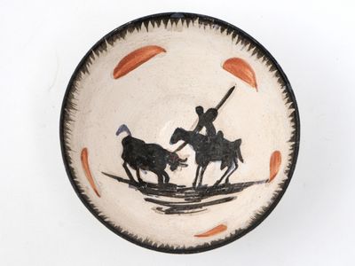 a black and white plate with a picture of a man on a horse and a man on a horse