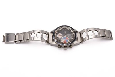 un gros plan d'une montre montée sur un bracelet en métal, posée sur une surface blanche