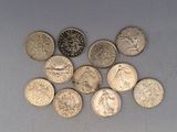 plusieurs types de pièces de monnaie sont disposés sur une surface blanche