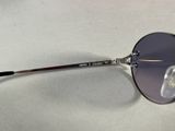 purple tinted sunglasses on a white surface with a black handle