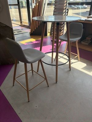 a table and two chairs in a room with a large window