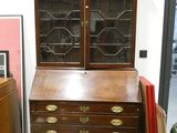 a wooden desk with a glass door and drawers