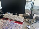 un bureau sur lequel se trouvent un ordinateur, un clavier, une souris et d'autres objets