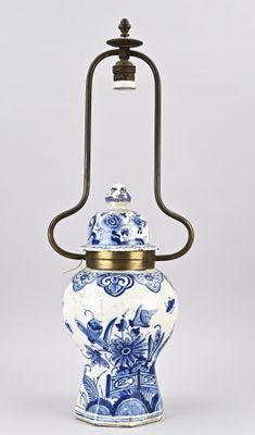 a blue and white vase with a brass handle