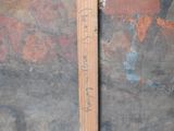 a piece of wood with writing on it next to a wall