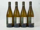 three bottles of white wine are lined up on a white surface