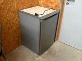 un petit réfrigérateur dans un coin de la pièce
