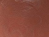 a brown plate with a dragon design on it
