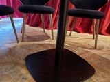 three chairs sitting at a table with a red curtain in the background