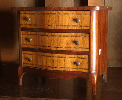 une petite commode en bois posée sur une table