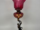 un bougeoir en verre rose avec un oiseau dessus
