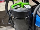 a blue and green vacuum sitting next to a blue and green bag