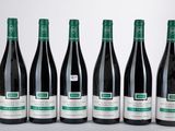 six bouteilles de vin sont alignées sur une table