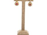 a pair of earrings on a stand with a white background