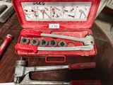 une mallette à outils rouge contenant des outils, posée sur une table