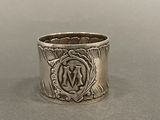 une vieille bague en argent ornée d'un motif, posée sur une table