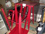 une table rouge sur laquelle est posé un parasol rouge