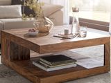 a coffee table with books and a vase on it