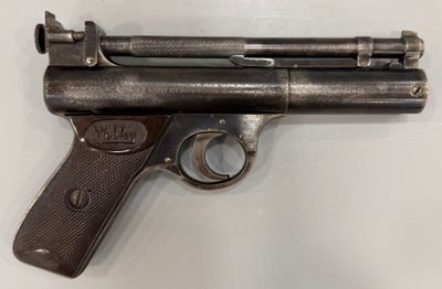 un vieux pistolet posé sur une table, sur fond blanc