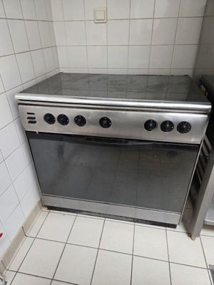 a stainless steel stove in a kitchen with tile flooring