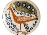 une assiette décorative ornée d'un oiseau et de fleurs