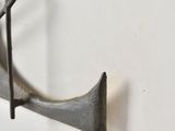 a metal hook that is hanging on a wall