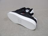 black and white sneakers with white soles sitting on a gray surface