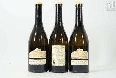 three bottles of wine are lined up on a white surface