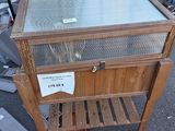 une table en bois avec un plateau en verre, posée dans la rue