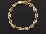 a gold bracelet with an intricate design