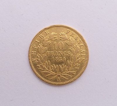 gros plan d'une pièce d'or sur une surface blanche