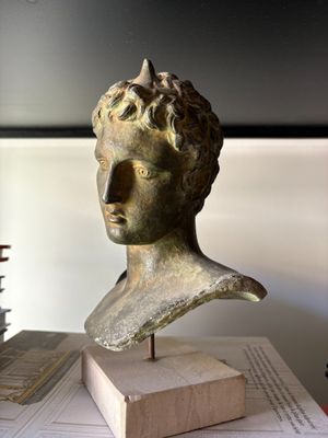 a bust of a man sitting on top of a book