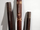 three baseball bats that are standing up against a wall