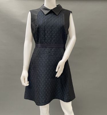 a mannequin wearing a black dress with a collar