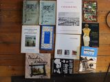 a lot of books on the floor next to a lamp