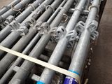 a large pile of steel pipes sitting on the ground