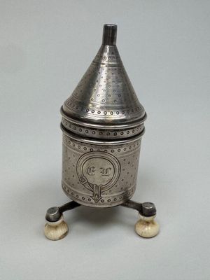 une boîte ancienne en métal argenté, munie d'un couvercle et d'une poignée, posée sur un socle