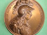 an image of a bronze medal with a woman wearing a hat