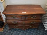 a small chest of drawers next to a radiator in a room