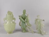 trois figurines en jade représentant des personnages asiatiques et un vase, posés sur un fond blanc