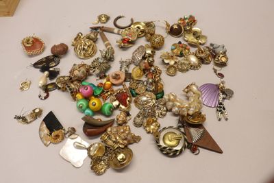 a pile of jewelry sitting on a table next to a pair of scissors